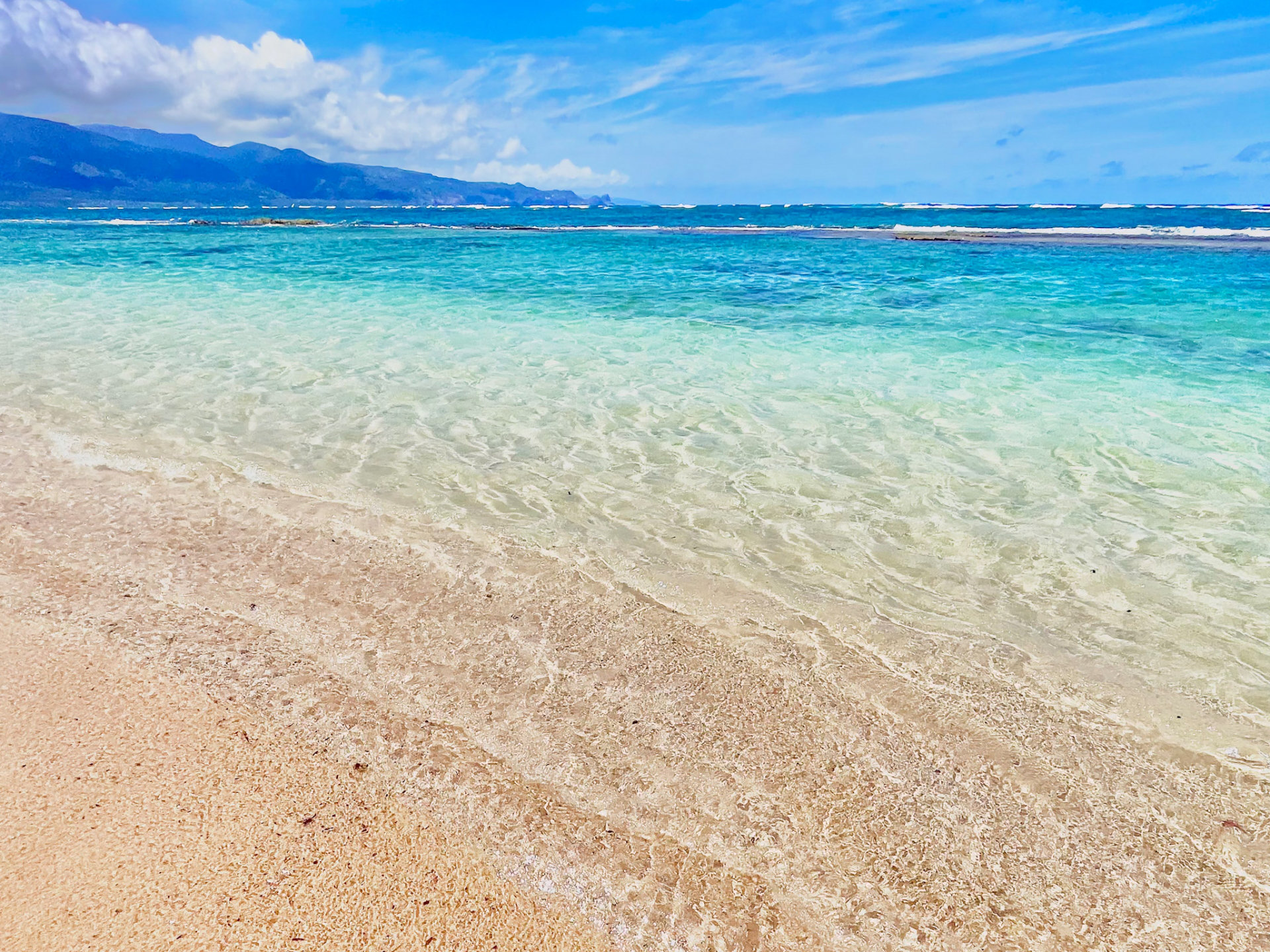 透明な海と砂浜が広がる穏やかなビーチの風景