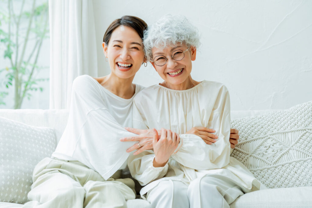 利用者と家族が自宅で笑顔で寄り添い過ごす様子