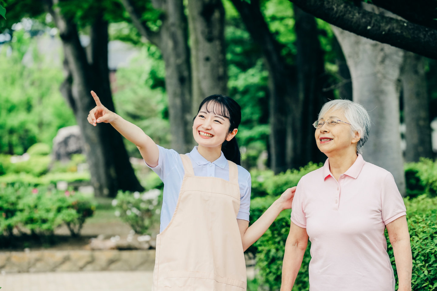 訪問看護スタッフが利用者と屋外で会話しながらサポートする様子